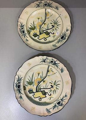 two plates with designs on them are hanging on a wall