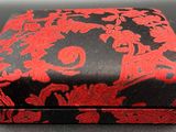 a black and red box with red flowers on it