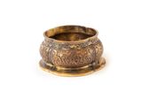 a close up of a brass bowl on a white surface