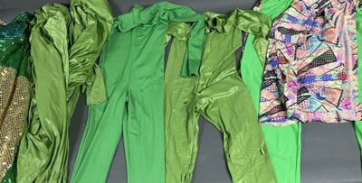 Plusieurs vêtements de différentes couleurs sont alignés sur une surface noire.