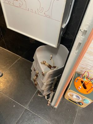 un tableau blanc accroché au mur, à côté d'une pile de bagages