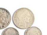 four different types of silver coins on a white surface