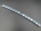 un gros plan d'un bracelet en argent orné de cristaux bleus
