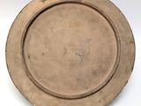 a brown plate with writing on it sitting on a white surface