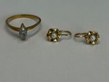 trois bagues et une bague sertie d'un diamant sur un fond blanc