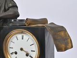 a statue of a man sitting on top of a clock