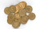 une pile de pièces d'or posée sur une surface blanche