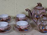 six tasses et une théière posées sur une table