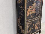 a black and gold chest of drawers in a room