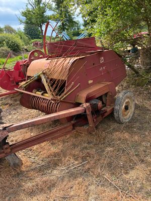 un tracteur rouge garé à côté d'un arbre