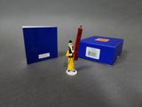 a small figurine of a man holding a pencil in front of a blue box