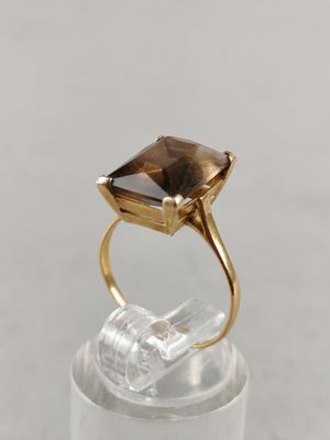 a close up of a gold ring with a smoky quartz stone in it