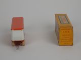 a small red and white truck next to a yellow box