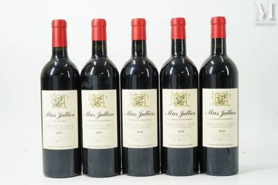 quatre bouteilles de vin sont alignées sur une surface blanche