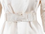 a close up of a woman ' s white dress with a belt