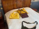 a bed with two bags on it and a purse on the bed