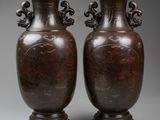 two brown vases sitting on top of a table next to each other