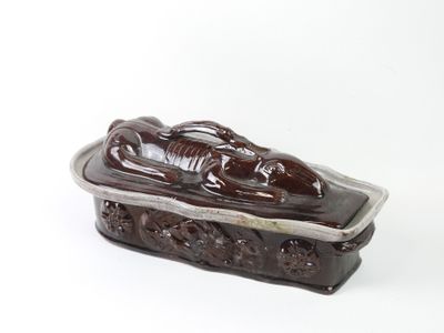 a brown box with a statue on it on a white surface