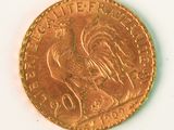 a gold coin with a rooster on it on a white surface