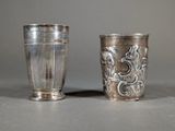 two silver cups sitting next to each other on a table