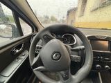 a steering wheel and dashboard of a car in the rain