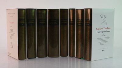 several books are lined up in a row on a white surface