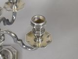 a silver candelier with two candles on it