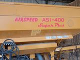 une machine jaune qui est garée dans la poussière
