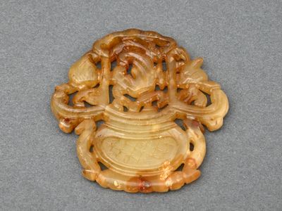 une image représentant un objet sculpté posé sur une table, sur fond gris