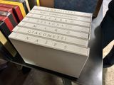 a stack of books sitting on a table next to a chair