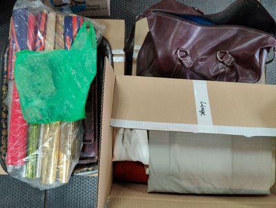 a box of clothes and a bag of luggage on the floor
