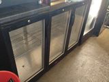 a red bucket sitting in front of a black and silver refrigerator