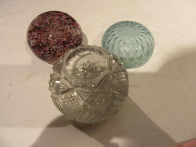 trois boules de verre posées les unes à côté des autres sur une table