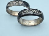 two black and white wedding rings on a blue surface