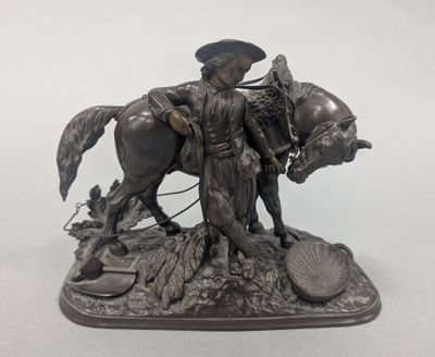 statue en bronze représentant un homme à cheval, avec un oiseau sur le dos