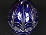 a blue glass vase that is sitting on a black surface