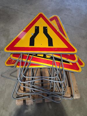 une pile de panneaux de signalisation sur une palette dans un entrepôt