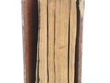 an old book that is open on a white surface