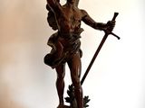 une statue représentant un homme tenant une épée, posée sur une table