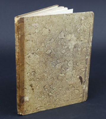 a close up of a book on a table with a black background