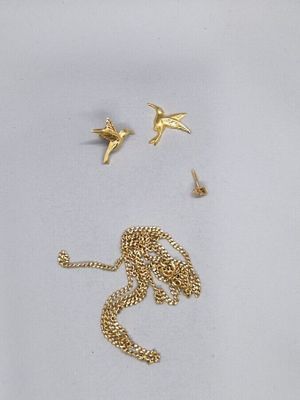 un collier en or et deux oiseaux sur un fond blanc