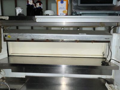 a stainless steel shelf with a microwave on top of it