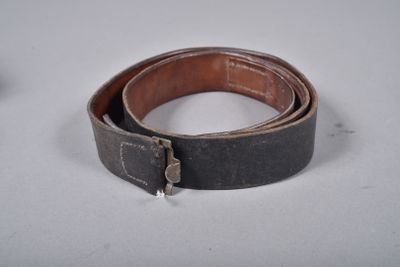 une vieille ceinture avec une boucle métallique sur un fond blanc