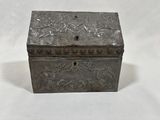 an antique silver box with a floral design on the lid