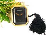 a black and gold watch with a tassel next to it