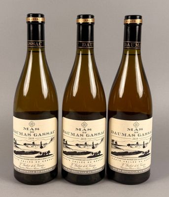 trois bouteilles de vin posées sur une table l'une à côté de l'autre