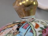a close up of a vase with a lid on a table