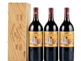 three bottles of red wine in a wooden box next to a wooden box
