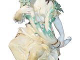 a figurine of a woman sitting on a chair