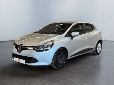 La voiture blanche est garée dans une pièce au sol gris.